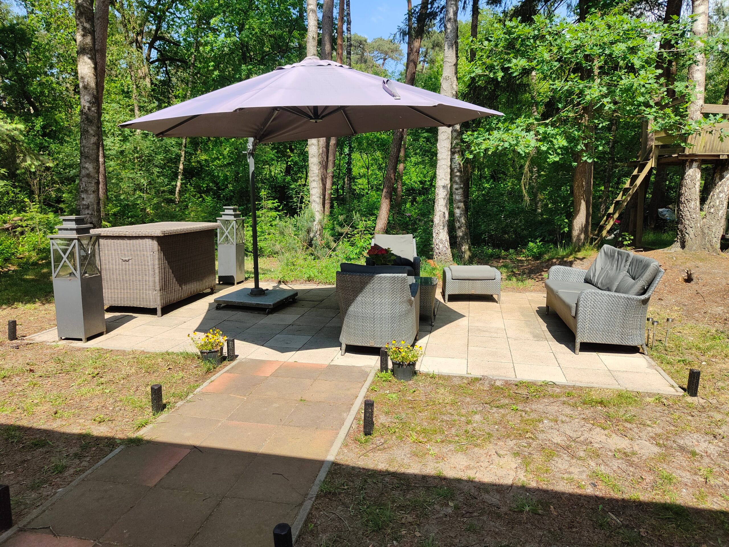 Parasol en ligstoelen op het terras bij de bungalow