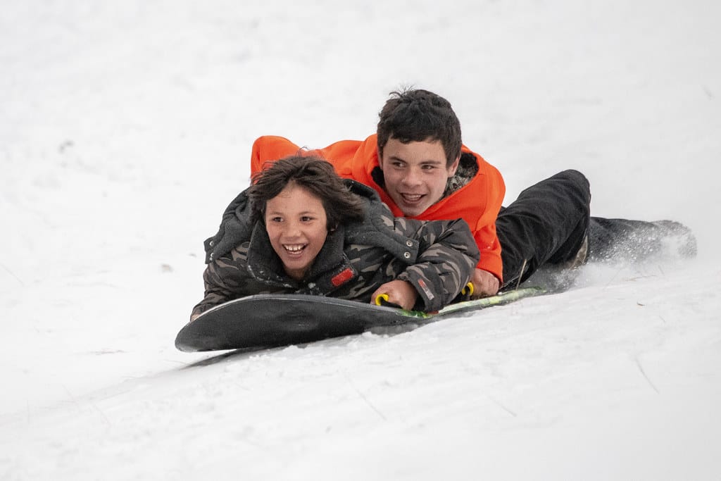 Kinderen op een slee in de sneeuw
